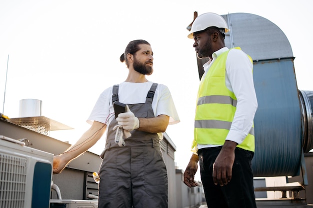 Artigiani che lavorano e mantengono i condizionatori sull'impianto
