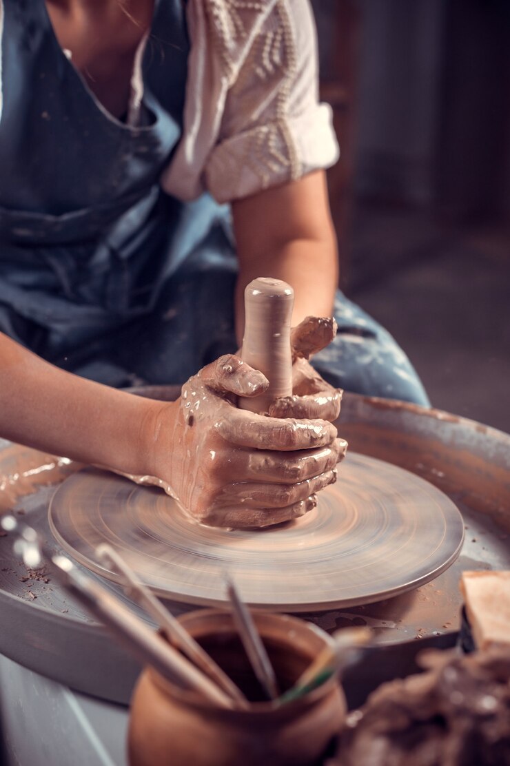Artigiano al suo volante per creare un nuovo capolavoro. Fare piatti in ceramica. Avvicinamento.