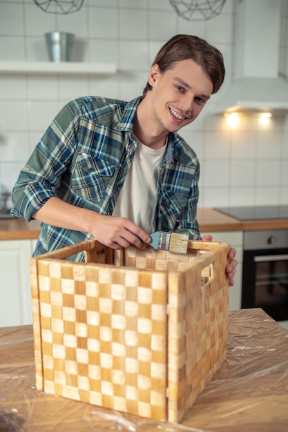 Artigiano che dipinge l'interno della scatola di legno