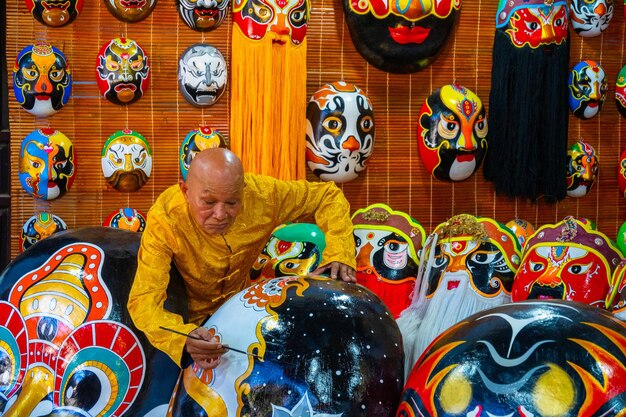 artigiano che fa maschere antiche fatte a mano nell'antica città di Hoi An Quang Nam Vietnam