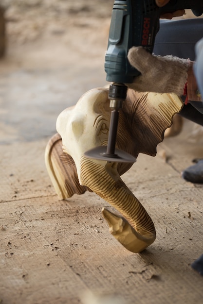 Artigiano tradizionale che scolpisce legno un elefante e un legno d&#39;insabbiamento