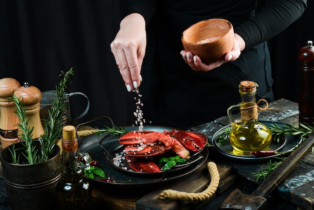 Artigli di aragosta di pesce su un piatto nelle mani dello chef Banner alimentare