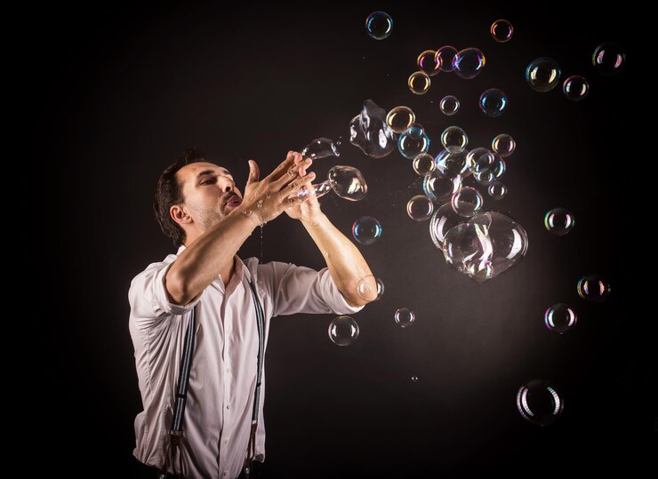 Foto artista che soffia molte bolle di sapone dalle sue mani. concetto di studio di spettacolo di bolle.