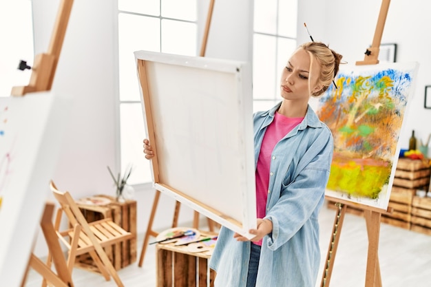 Artista di giovane donna caucasica che guarda disegnare in studio d'arte