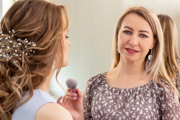 Artista di trucco che mette sul trucco sul modello