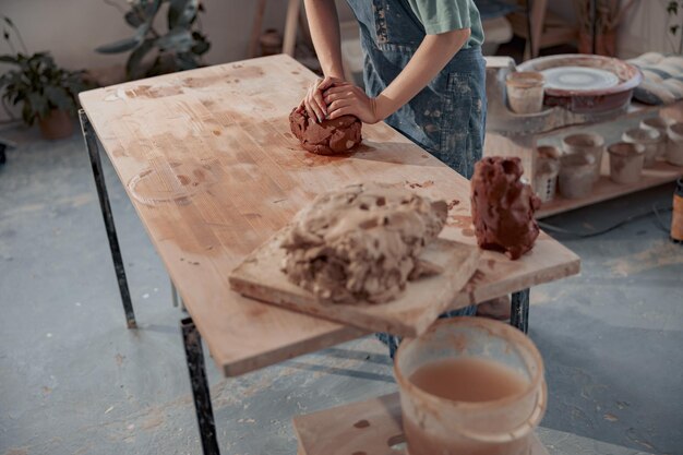 Artista fatto a mano che modella l'argilla mentre realizza la ceramica nel laboratorio di ceramiche