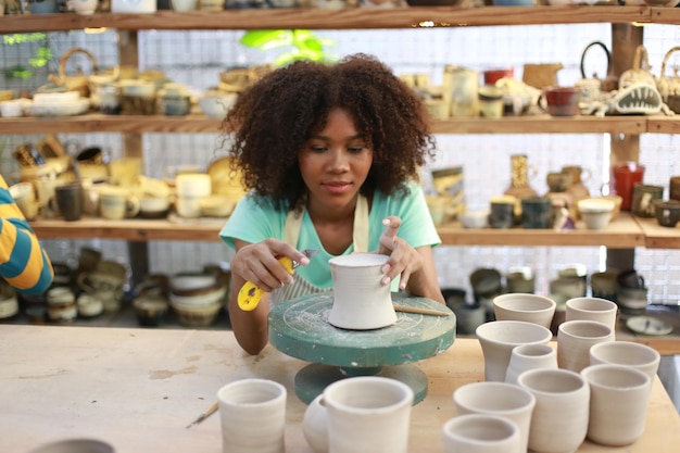 Artista in ceramica che dipinge la superficie esterna del pezzo di ceramica