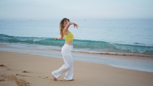 Artista sensuale che balla le onde dell'oceano sera estiva donna ballerina che muove il corpo