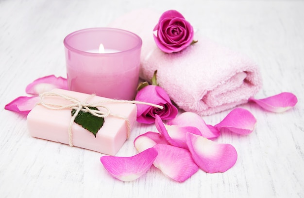 Asciugamani da bagno, candele e sapone con rose rosa