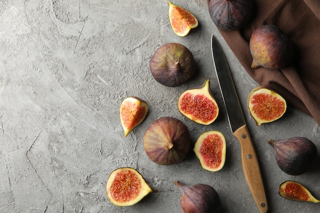 Asciugamano, coltello e fico su grigio, vista dall'alto