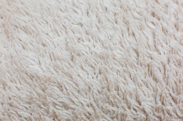 Asciugamano di cotone beige o tappeto soffice texture di sfondo. Primo piano, foto macro. Immagine con messa a fuoco morbida.