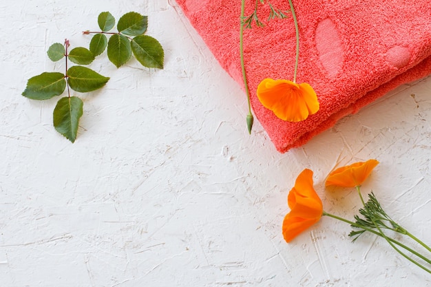 Asciugamano e fiori di Eschscholzia californica su sfondo bianco