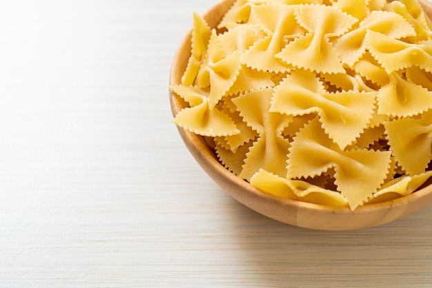 Asciugare la pasta cruda delle farfalle in una ciotola di legno