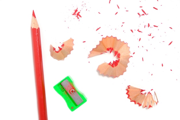Asciugatrice e matita rossa affilata con segatura su sfondo bianco