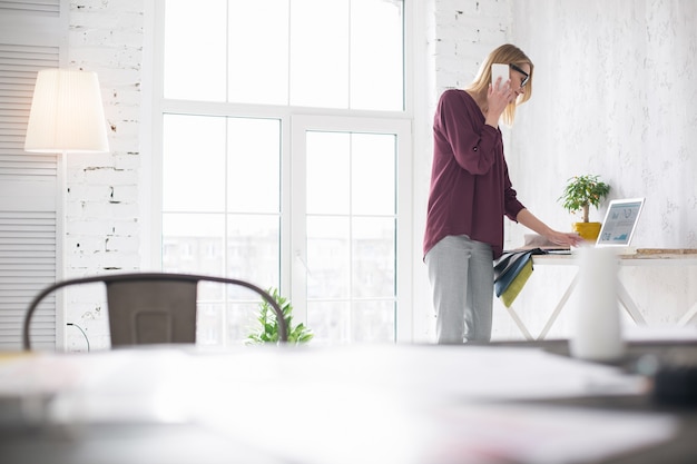 Ascoltati. Libero professionista femminile professionale in piedi e che fa chiamata