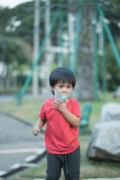 Asia bambino sorridente giocando sulla barra di scorrimento giocattolo parco giochi all'aperto felice bambino in età prescolare che si diverte mentre gioca sull'attrezzatura del parco giochi durante il giorno in estate