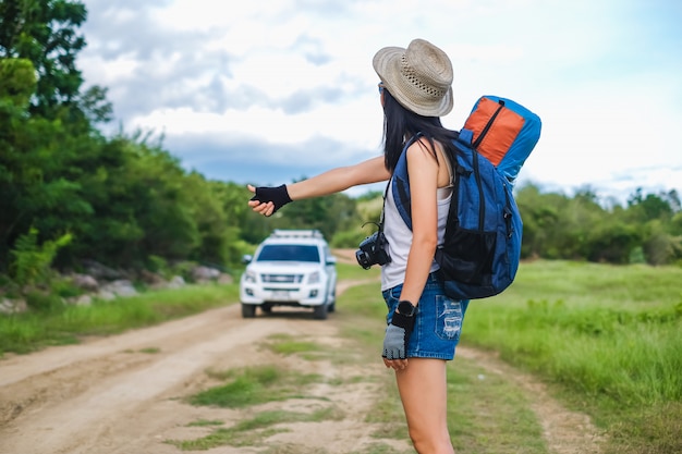 Asia donna viaggiatore autostop per andare a destinazione nel suo viaggio.