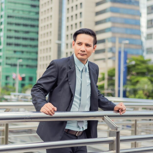 Asia giovane uomo d&#39;affari di fronte al moderno edificio nel centro della città.