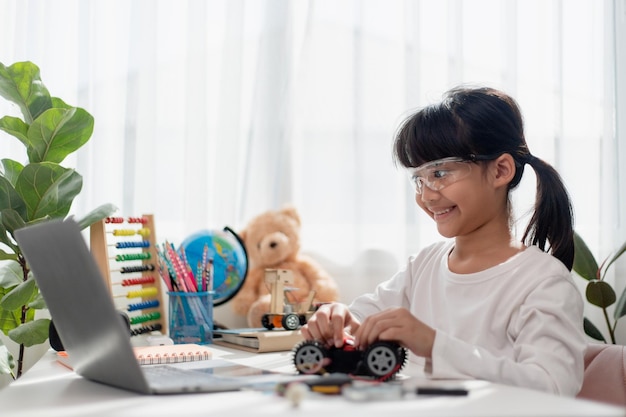 asia students learn at home in coding robot cars and electronic board cables in stem steam mathematics engineering science technology computer code in robotics for kids concept
