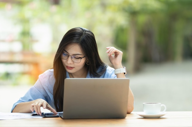 Asia Woman sta lavorando su personal computer e smartphone su Internet e lavora da casa