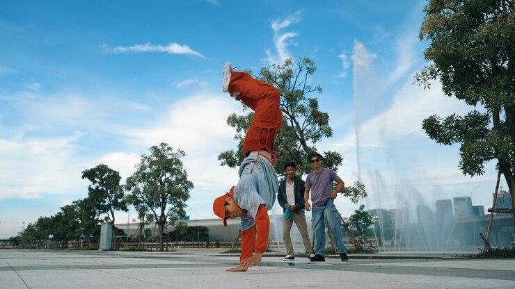 Photo asian skilled hipster doing freeze pose at camera near fountain sprightly