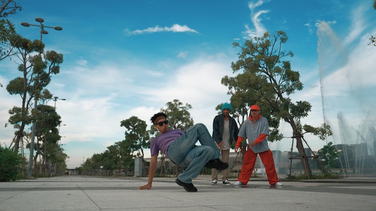 Photo asian skilled hipster doing freeze pose at camera near fountain sprightly