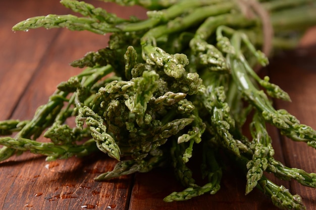 Asparagi Asparagi verdi freschi su sfondo tavolo in legno Mazzo di asparagi verdi freschi maturi verdure biologiche pronte per cucinare o grigliare