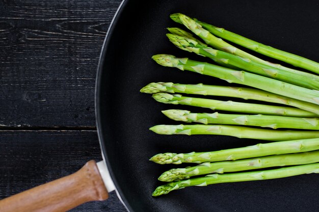 Asparagi freschi crudi in padella.