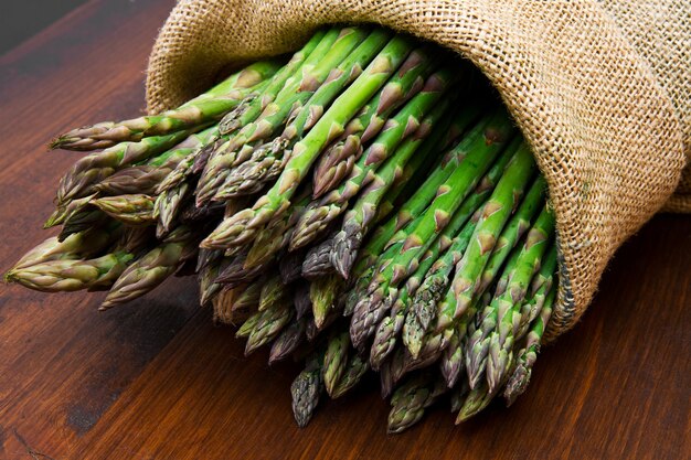 Asparagi in sacco di tela su legno