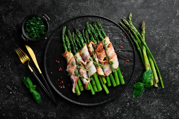 Asparagi verdi alla griglia avvolti con pancetta Cibo sano su sfondo di pietra Vista dall'alto