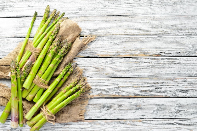 Asparagi verdi freschi su fondo di legno bianco Cibo sano Vista dall'alto Spazio libero per il testo