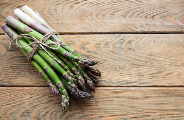 Asparagi verdi freschi sulla vecchia tavola di legno. Lay piatto