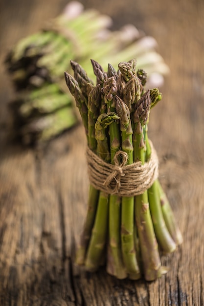 Asparagi verdi freschi sulla vecchia tavola di quercia.