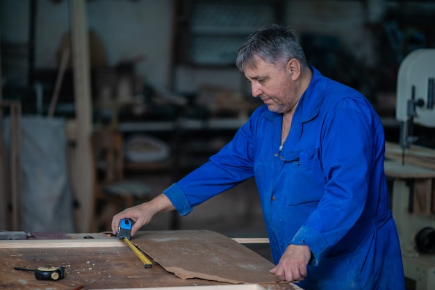 Assemblaggio del telaio di legno sul tavolo di carpenteria in officina con colla e strumenti diversi