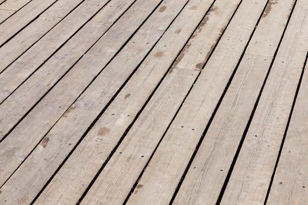 Assi del pavimento nel gazebo. Piano in legno oscurato dall'ambiente. Foto da vicino