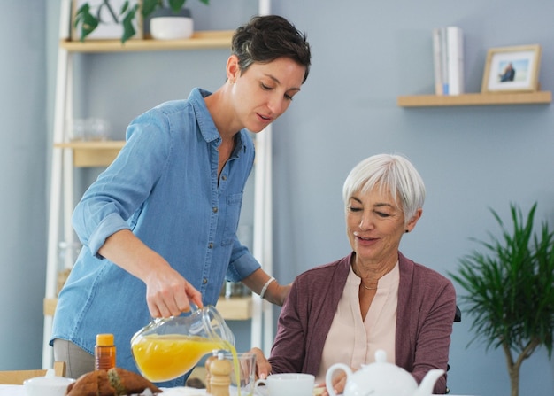 Assicurati di ottenere la tua foto ritagliata di vitamina C di una donna anziana felice seduta e fare colazione con la sua giovane figlia attraente mentre è a casa