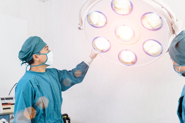 Assistente chirurgo che prepara lampade chirurgiche in sala operatoria