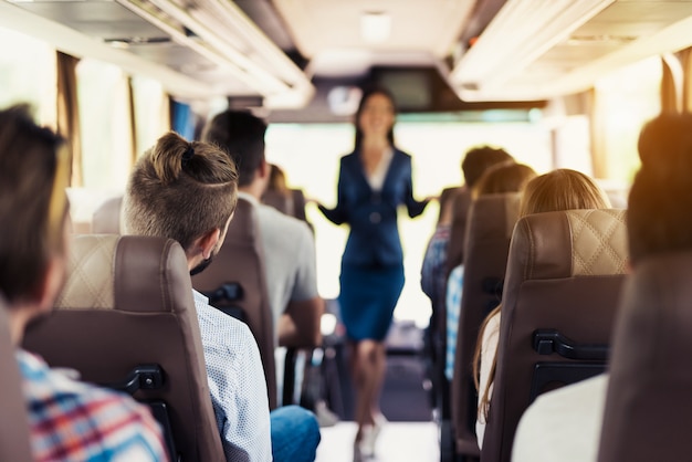 Assistente di autobus in uniforme e passeggeri felici.