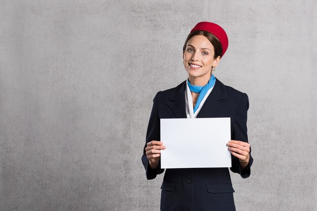 Assistente di volo che tiene segno bianco