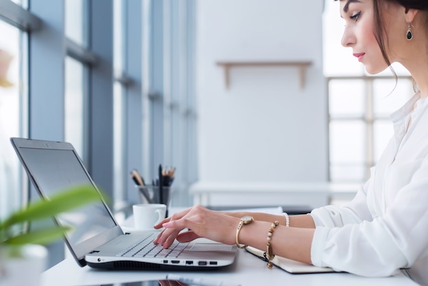 assistente femminile che lavora, digita, utilizza computer portatile, concentrata, guardando il monitor. Impiegato di ufficio che legge la posta elettronica aziendale.