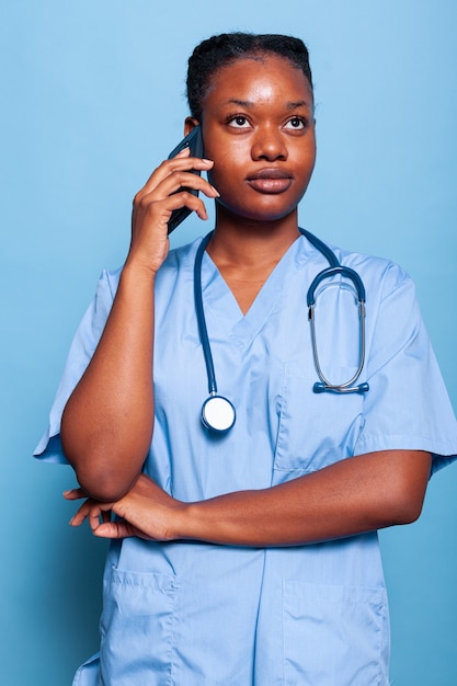Assistente medico afroamericano che parla allo smartphone discutendo l'esperienza della malattia