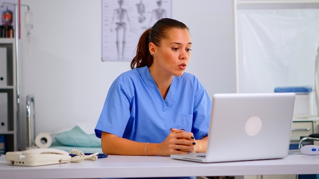 Assistente praticante donna che offre consulenza medica online per la diagnosi del paziente. Medico che utilizza la discussione virtuale per consultare il paziente, la telemedicina e il supporto sanitario, aiuto per riunioni virtuali