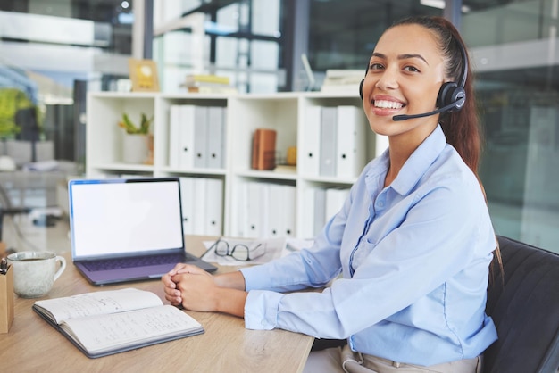 Assistenza clienti del call center e ritratto di donna latina alla scrivania in ufficio aziendale su cuffia per laptop e sorriso Receptionist crm e amichevole agente di consulenza femminile che lavora nel servizio clienti