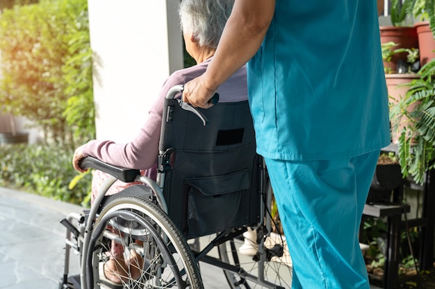 Assistenza e cura del caregiver Paziente asiatico anziano o anziano donna seduto su sedia a rotelle su rampa in ospedale di cura sano concetto medico forte