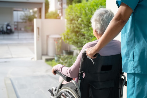 Assistenza e cura del caregiver Paziente asiatico anziano o anziano donna seduto su sedia a rotelle su rampa in ospedale di cura sano concetto medico forte