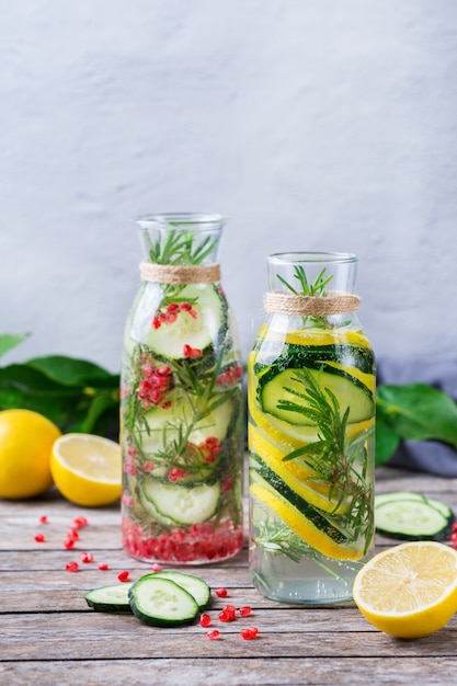 Assistenza sanitaria, fitness, concetto di dieta sana alimentazione. Fresco fresco limone cetriolo rosmarino melograno acqua infusa, bevanda disintossicante, limonata in un barattolo di vetro per le giornate primaverili estive. Copia lo sfondo dello spazio