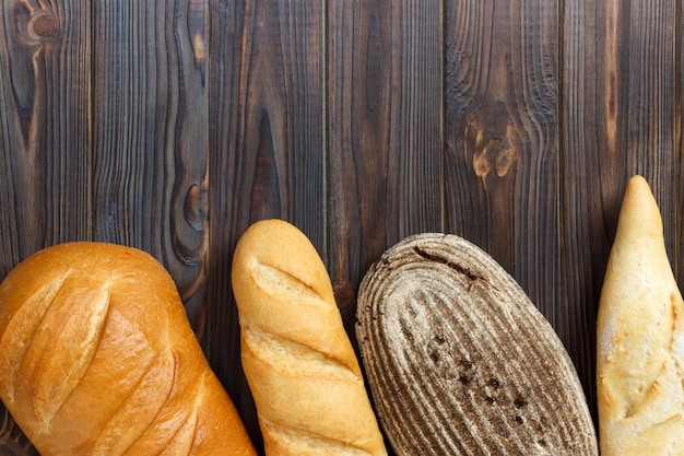 Assortimento del pane fresco su fondo di superficie di legno