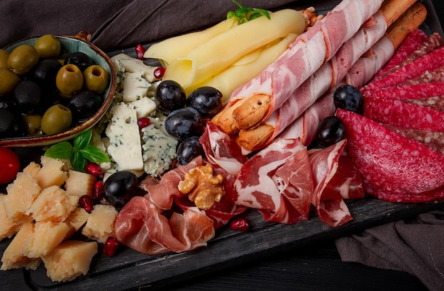 Assortimento di antipasti salsiccia e formaggio su una tavola di legno vista dall'alto senza persone