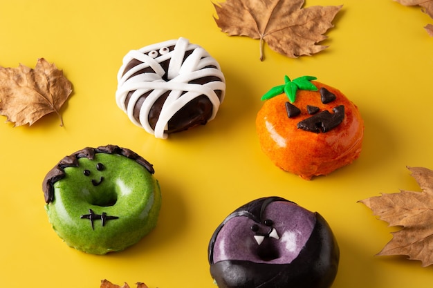 Assortimento di ciambelle di Halloween su sfondo giallo