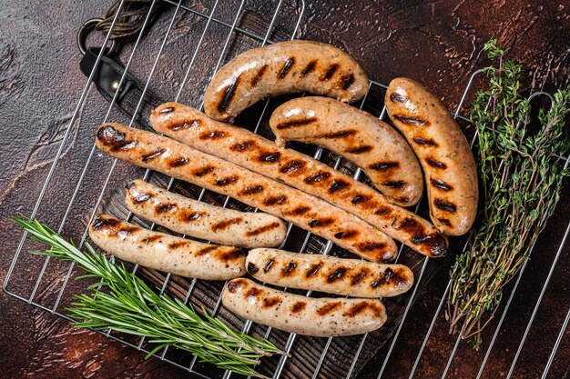 Assortimento di diverse salsicce alla griglia barbecue con carne di manzo, maiale, agnello e pollo alla griglia Sfondo scuro Vista dall'alto